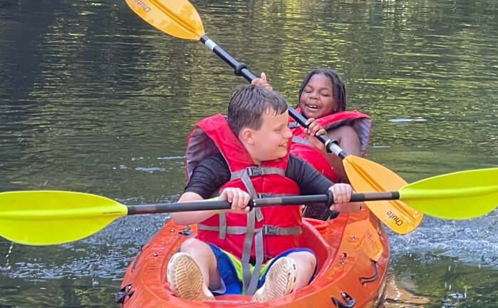 Two kids on a rowing boat having fun