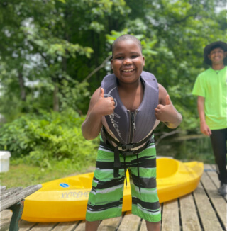 Kid wearing life vest smiling at camera